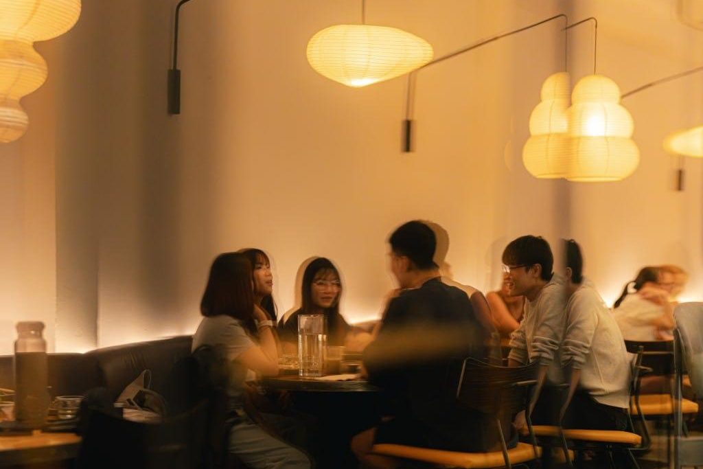 Inner Circle members at a table under paper lamps at Cafe Gyoen